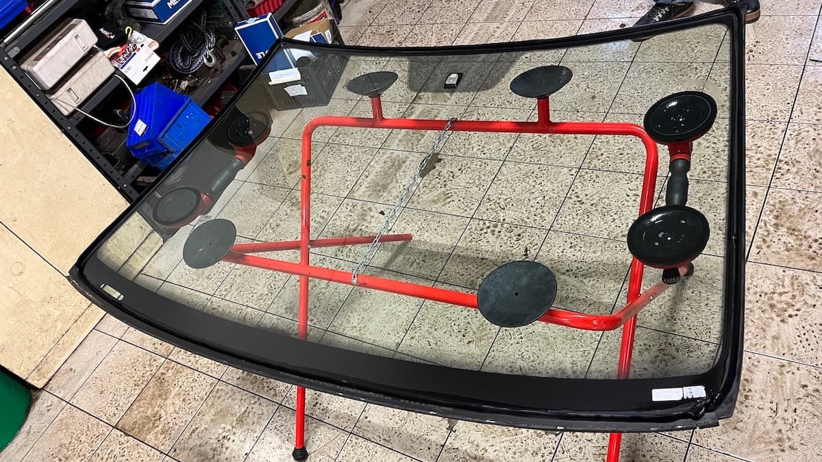 Szyba czołowa przygotowana do wymiana, leży na profesjonalnym stojaku